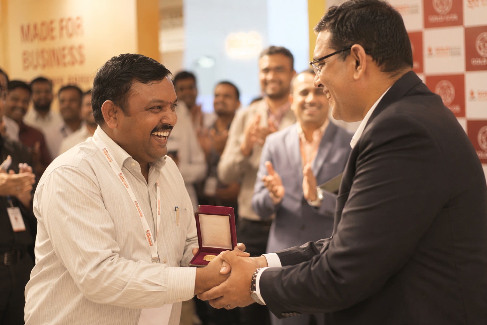 Dealer receiving a gold coin reward at a trade event